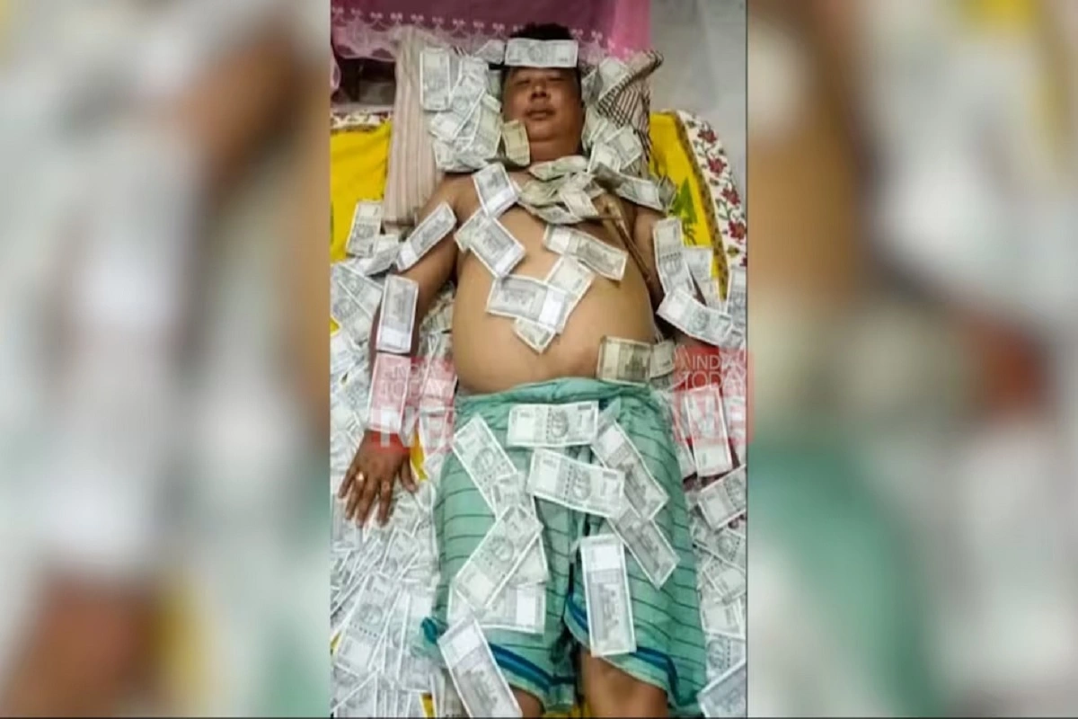 असम: नोटों की गड्डियों के साथ सोने वाले शख्स की तस्वीर पर विवाद, इस पार्टी से संबंध की बात