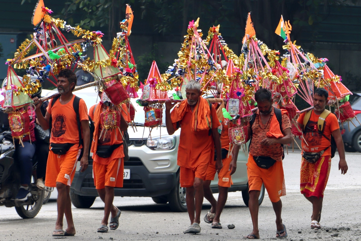 New Delhi: Lord Shiva devotees or 'Kanwariyas' walk during the 'Kanwar Yatra' carrying holy water from the Ganga river in the holy month of 'Shravan', in New Delhi , Friday, July 07, 2023. (Photo: IANS/Wasim sarvar)