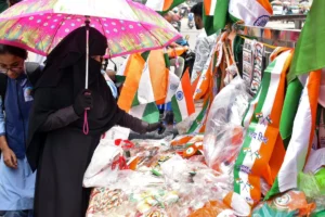 Meerut: A woman wearing a hijab shops for a national flag on the eve of the 78th Independence Day celebrations in Meerut on Wednesday, August 14, 2024. (Photo: IANS)