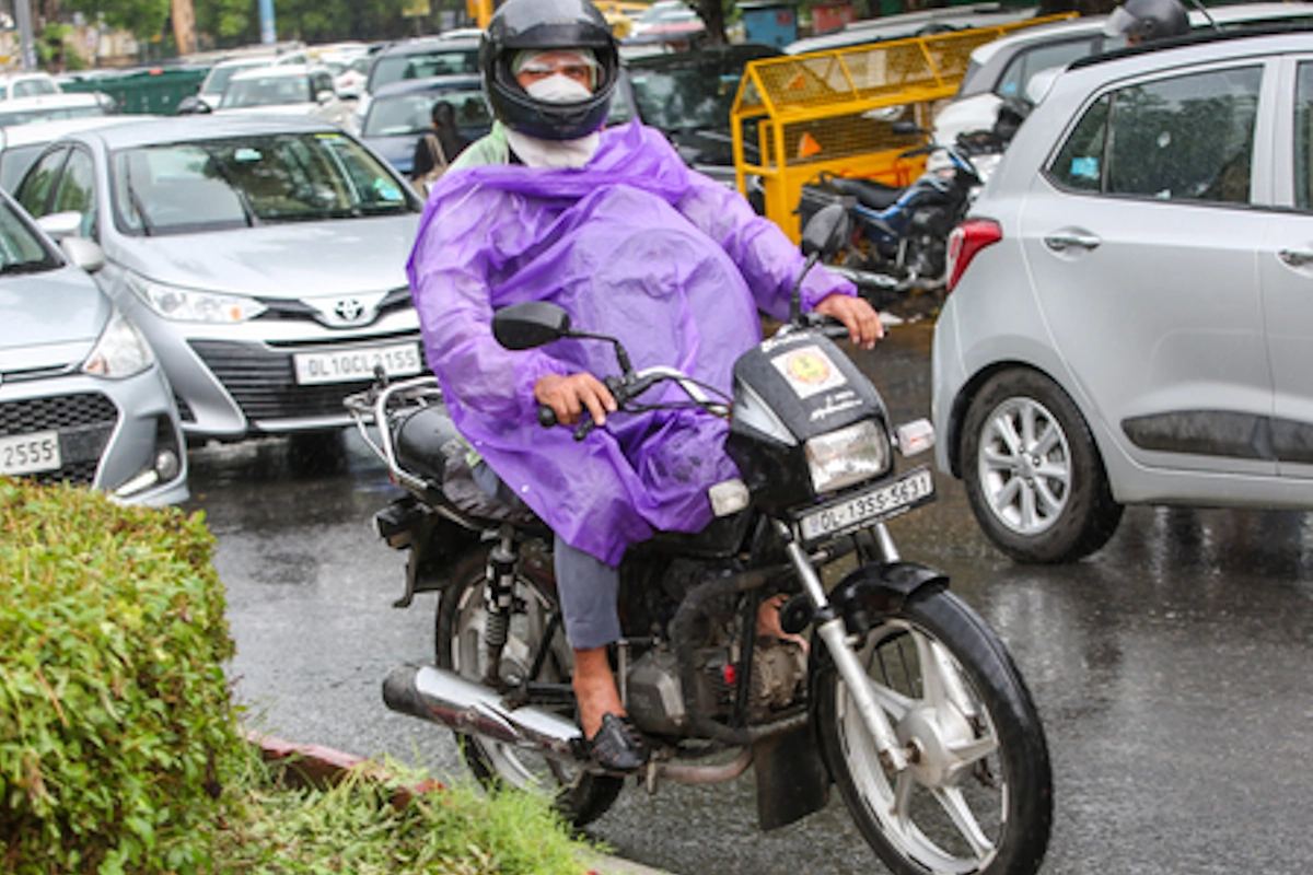 भारी बारिश के बीच बैग बचाता यात्री